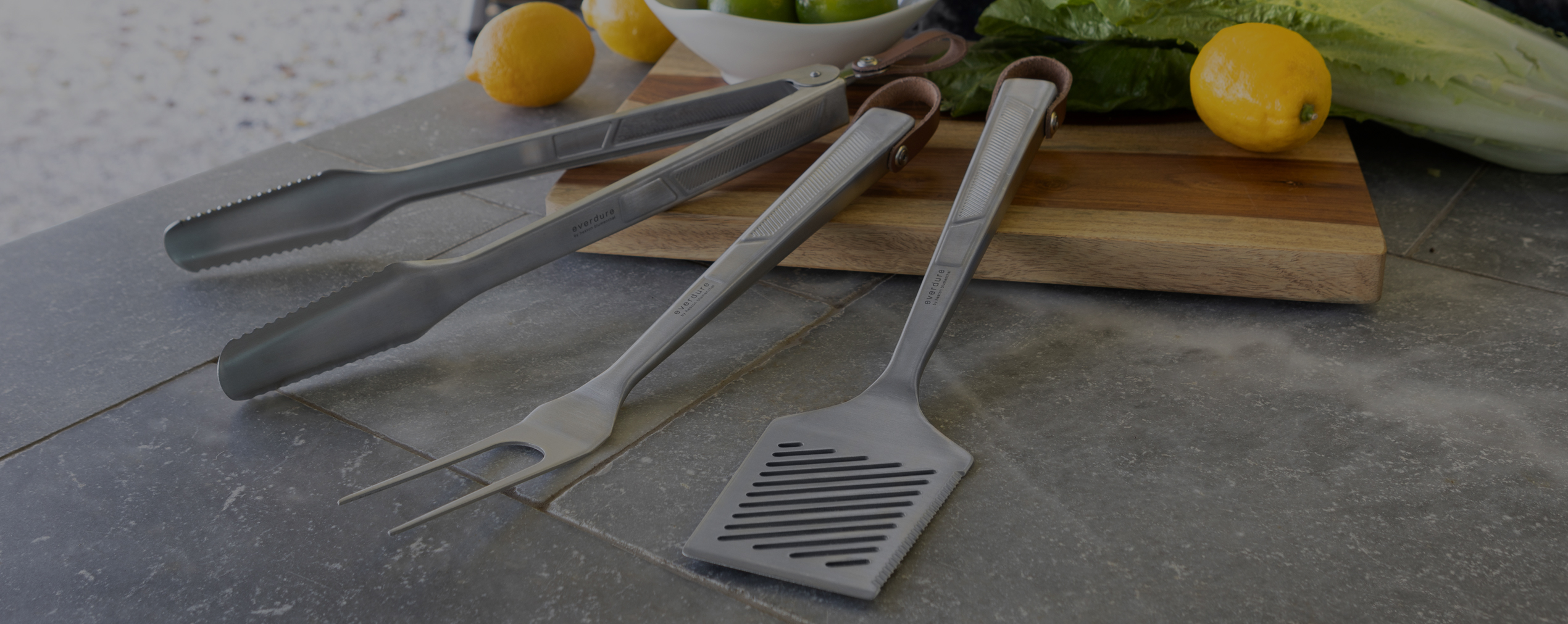 Quantum steel spatula fork and tongs on a chopping board